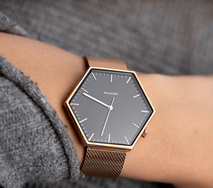 Solgaard eco friendly watch with hexagon watch face and gold metal strap on wrist