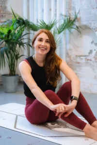 Bridget founder of Kala Pilates sitting on a yoga mat