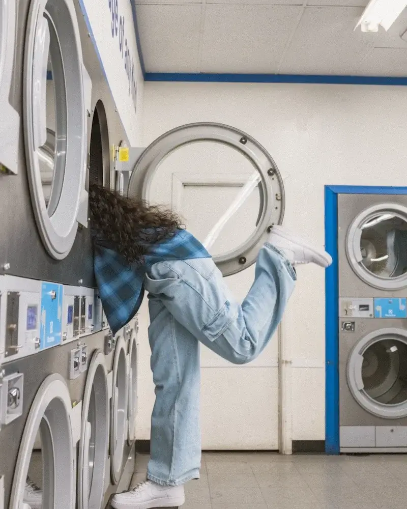 Woman leaning into washing machine