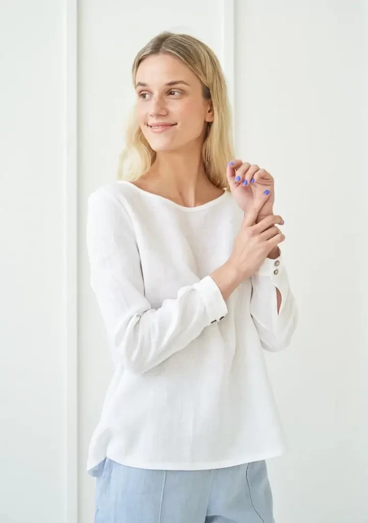 Model standing wearing a white linen top