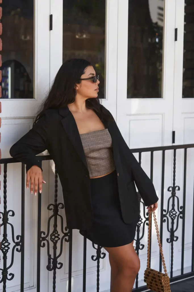 Girl leaning on railing wearing Whimsy + Row blazer and sunglasses